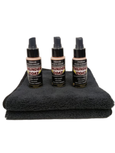 Three bottles of wounder coat on a black towel.